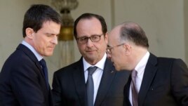 French President Francois Hollande (C) speaks with Interior minister Bernard Cazeneuve (R) and Prime Minister Manuel Valls at the end of the weekly cabinet meeting at the Elysee Palace in Paris, April 22, 2015.