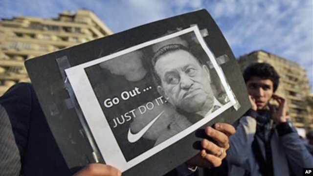 A protester holds a placard showing Egyptian President Hosni Mubarak and reading "Go out... Just do it" at the continuing anti-government demonstration in Tahrir Square in downtown Cairo, Egypt, February 10, 2011.