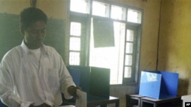 A man casts an advance vote at a local election commission office in Rangoon, 06 Nov  2010