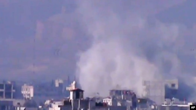 In this image from video obtained from the Shaam News Network, smoke rises due to shelling in the Damascus countryside, Jan. 2, 2013.