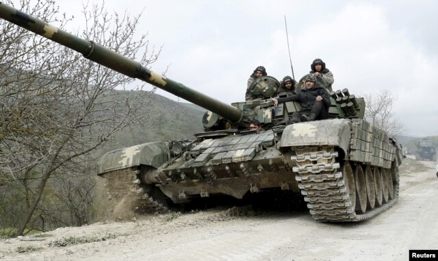 FILE - A tank of the self-defense army of Nagorno-Karabakh moves on the road near the village of Mataghis, April 6, 2016.