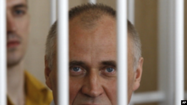 A former opposition presidential candidate Nikolai Statkevich sits in a cage during a court session in Minsk, Belarus, Thursday, May 26, 2011