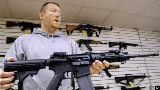 FILE - John Jackson, co-owner of Capitol City Arms Supply shows off an AR-15 assault rifle for sale at his business in Springfield, Illinois, Jan. 16, 2013.