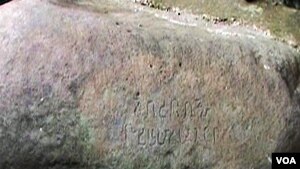 Pada prasasti terdapat dua baris tulisan Sunda kuno, gambar telapak tangan, telapak kaki, dan wajah.