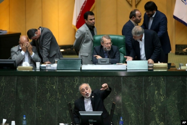 FILE - Head of Iran's Atomic Energy Organization Ali Akbar Salehi, bottom, speaks in an open session of parliament while discussing a bill on Iran's nuclear deal with world powers, in Tehran, Iran, Oct. 11, 2015.