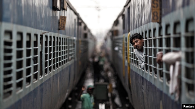 A passenger looks through the window of a stalled train as he waits for electricity to be restored at a railway station in New Delhi, India, July 31, 2012. 