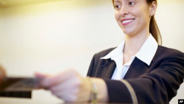 The ticket clerk is smiling.  We don’t see the customer’s face.