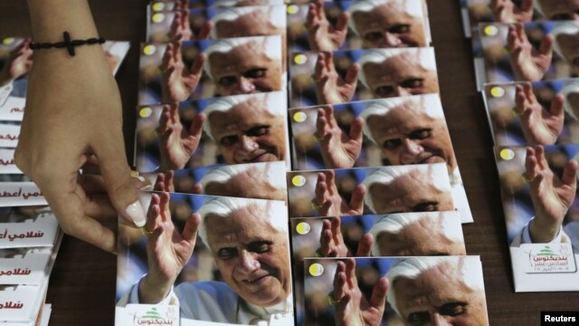 Una mujer ordena discos de música religiosa de Benedicto XVI. En el Líbano ha habido preparativos para la llegada del Papa.