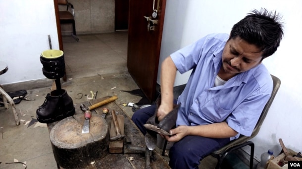 A worker is designing special shoes for leprosy patients at the Leprosy Mission Trust India hospital, Kolkata, Sept. 20 2016. (M. Hussain/VOA)