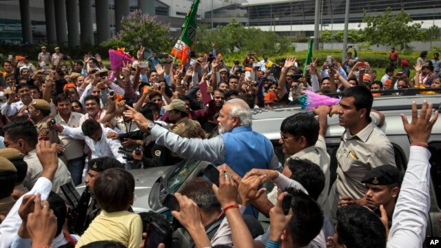 Lãnh đạo đảng đối lập Narendra Modi chào đón đám đông bên ngoài sân bay New Delhi, Ấn Độ, 17/5/2014.