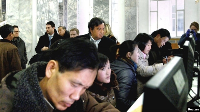 Former New Mexico Governor Bill Richardson (C, back row) looks at North Koreans working on computers at the Grand People's Study House in Pyongyang, January 9, 2013 in this picture released by the North Korea's KCNA news agency. 