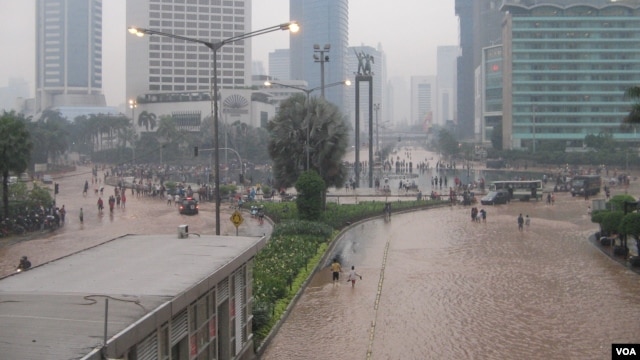 Kawasan Jl MH Thamrin menuju Bundaran HI hingga Jalan Jenderal Sudirman Jakarta digenangi banjir hingga ketinggian 50 centimeter, Kamis malam 17/1 (foto: VOA/Andylala)