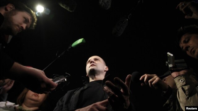 Opposition leader Sergei Udaltsov (C) talks to the media after leaving a building of the Russian Investigative Committee in Moscow, October 17, 2012. Russian investigators have begun criminal proceedings against the prominent leader of protests against Pr