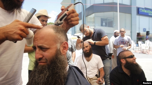 Ahmad Assir (L) and his supporters shave their heads during the sit-in in Sidon July 4, 2012.