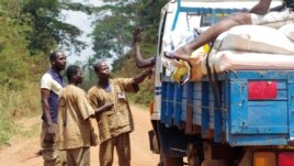 Traditional hunters known as dozos accost a truck driver at an illegal checkpoint north of the western Ivory Coast town of Duekoue, February 15, 2013. (Robbie Corey-Boulet for VOA)  