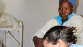 Stephanie Benn exercises a patient with cerebral palsy, as the child’s mother looks on (Photos:D.Taylor)