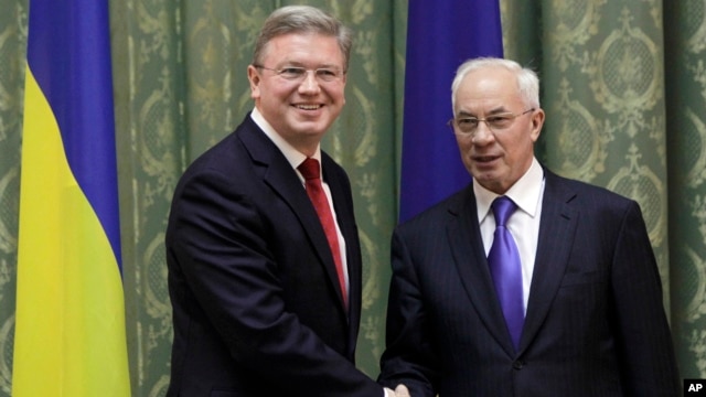 European Commissioner for Enlargement and European Neighborhood Policy Stefan Fuele, left, shakes hands with Ukraine Prime Minister Mykola Azarov during their meeting in Kiev, Ukraine,  February 7, 2013.