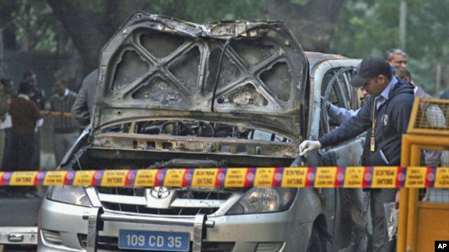 Police and forensic officials examine a damaged Israeli embassy car after an explosion in New Delhi, February 13, 2012.