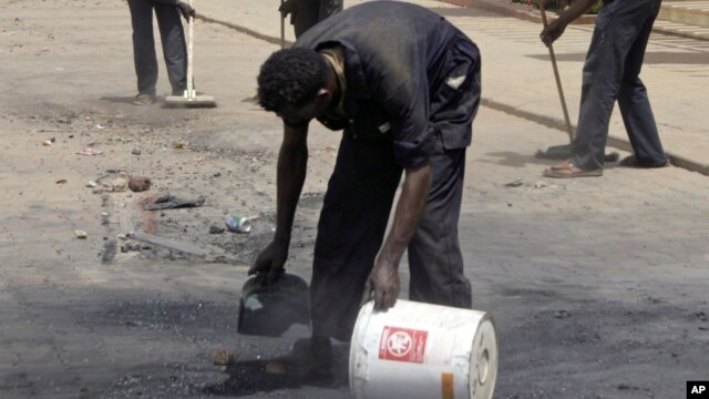 Workers outside the Qurtoba conference hall clean up debris after demonstrations by Sudanese university students and citizens yesterday in the capital Khartoum, Sudan, June 24, 2012.