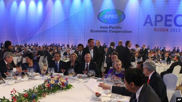 Russian President Vladimir Putin, center, and U.S. Secretary of State Hillary Clinton, fourth right, attend a reception at the APEC summit in Vladivostok, Sept. 8, 2012.