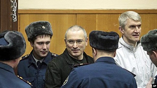 Mikhail Khodorkovsky, center, and his co-defendant Platon Lebedev, right, are escorted to a court room in Moscow, 27 Dec 2010.