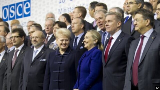 US Secretary of State Hillary Rodham Clinton, center, is flanked by Lithuania's FM Audronius Azubalis, right, and Lithuania's President Dalia Grybauskaite, left, as they attend an international conference of the Organization for Security and Cooperation i
