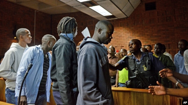 Les suspects non identifiés laissant le tribunal, à Prétoria, le 7 fév. 2013