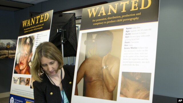 Deputy Assistant Director Immigration and Customs Enforcement (ICE) Office of Public Affairs Cathy Milhoan displays posters of suspects during a news conference at ICE headquarters in Washington, Thursday, Jan. 3,  2013, where ICE Director John Morton ann