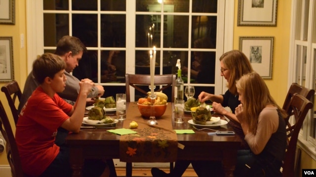 Jane Rassmussen's family sits down to a dinner inspired by her recent cooking lessons. (VOA/S. Koster)