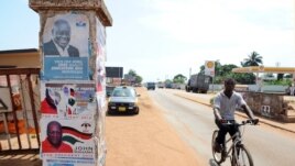 Wani yana wucewa kusa da hotunan 'yan takara a Ghana