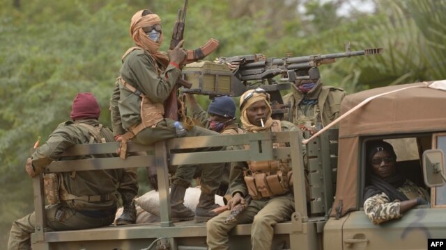 Malian soldiers patrol aboard a vehicle mounted with a machine gun in a street of Diabaly (400km north of the capital Bamako), January 26, 2013. 