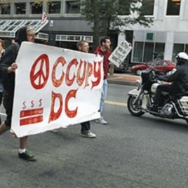 A police on a motorcycle passes a group of Occupy DC protesters as they march from McPherson Square to a Bank of America on K Street in Washington, October 20, 2011.