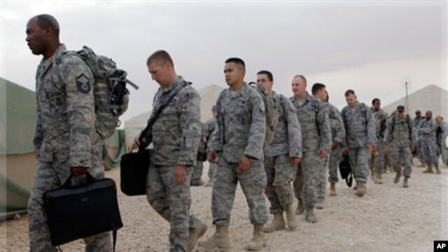 U.S. servicemen line up to board a bus as they begin their journey home at al-Asad Air Base west of Baghdad, Iraq, Tuesday, Nov. 1 , 2011.