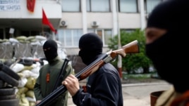 Armed pro-Russian rebels stand guard outside the town hall in Mariupol, eastern Ukraine, May 4, 2014.