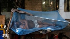 A laborer sleeps under a mosquito net on a hot summer morning in New Delhi