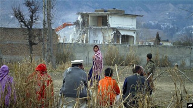 A Pakistan family watches the destruction of Osama bin Laden's compound in Abbottabad, Pakistan, February 26, 2012. 
