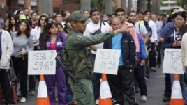 Cientos de personas esperan pacientemente en filas, en las afueras de un lugar de votación en Caracas, 
Venezuela.