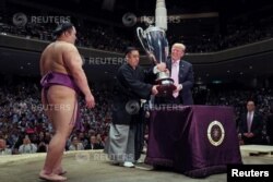 El presidente de EE.UU., Donald Trump, se prepara para entregar la Copa del Presidente al luchador de sumo Asanoyama, ganador del Gran Torneo de Sumo de Verano en el Ryogoku Kokigikan Sumo Hall, en Tokio. Mayo 26, de 2019.
