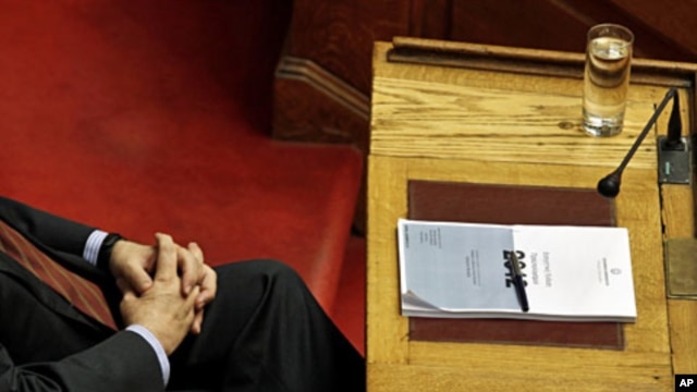 Greek PM Lucas Papademos attends a parliament session with a copy of Greece's 2012 budget placed on his desk in Athens, November 18, 2011