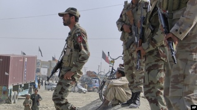Paramilitary soldiers stand guard along a road where tribesmen gathered to protest against an alleged firing incident in Chaman, along the Afghan border June 17, 2011.