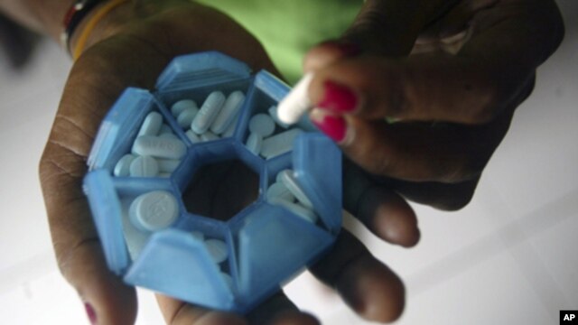 A woman infected with HIV prepares her medicines in a shelter house in Jayapura of the Indonesia Papua province.