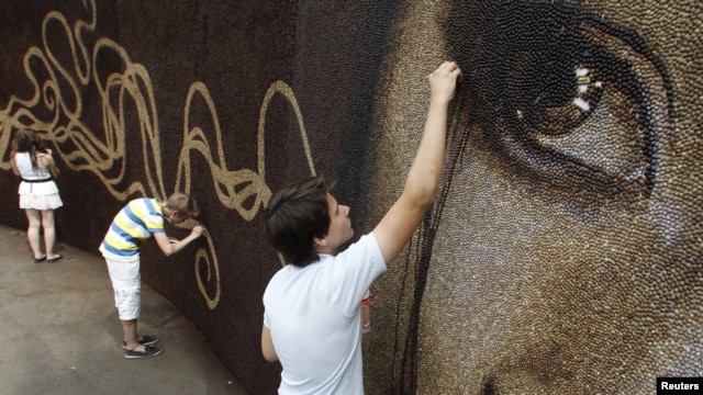Assistants put the finishing touches on artwork project in Russia's Gorky Park, June 26, 2012.