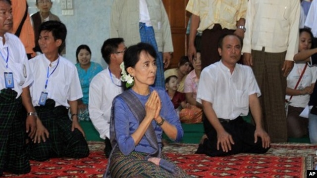 Burmese democracy icon Aung San Suu Kyi, center, pays her respects to a senior Buddhist monk during her visit to a Buddhist monastery in Bago, north of Rangoon, Burma, August 14, 2011