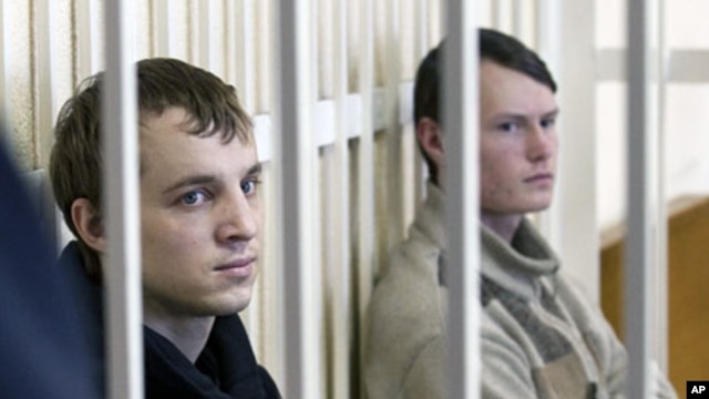Leader of the Young Front opposition group Dmitry Dashkevich (l) and opposition activist Eduard Lobov during a court hearing in Minsk, March 24 2011