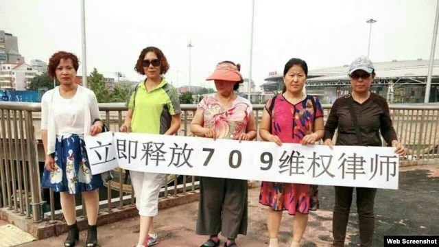 中国维权人士6月12日在北京举牌要求当局释放709律师(参与网图片)