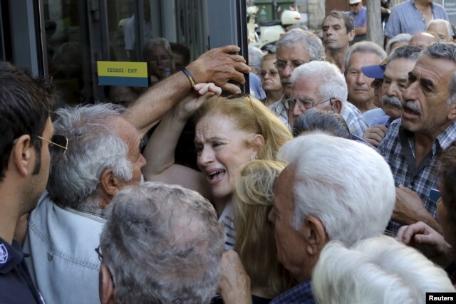 A pensioner (C) reacts as she tries to enter a National Bank branch to receive part of her pension at the city of Iraklio in the island of Crete, Greece July 9, 2015.