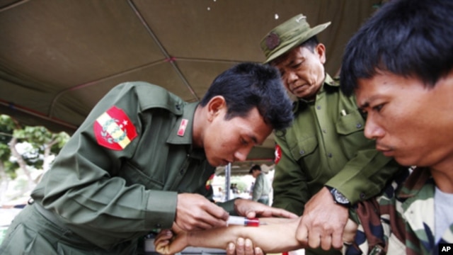 A soldier injects medicine into an earthquake survivor at a temple in Mine Lin village, Burma, March 27, 2011.