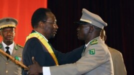 Mali's Interim President Dioncounda Traore (L) is congratulated by coup leader Amadou Sanogo after being sworn in at a ceremony in Bamako, Mali, April 12, 2012. 
