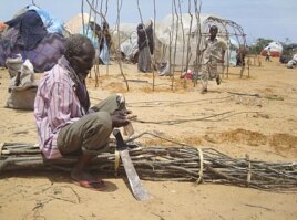 A man from drought-stricken southern Somalia cuts tree branches to construct a makeshift shelter in refugee camp in the capital, Mogadishu.
