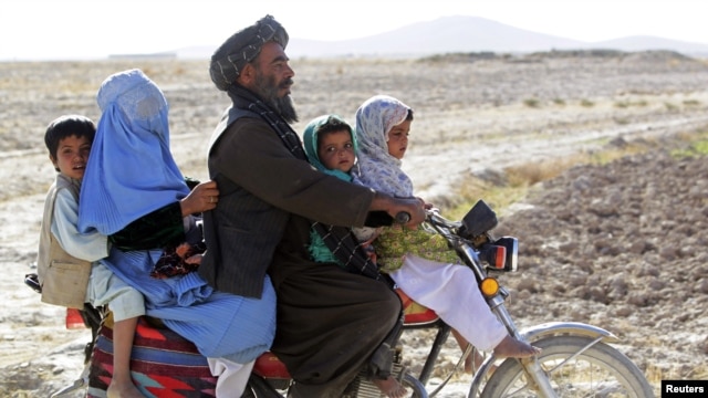 Cư dân lái xe gắn máy trên một con đường trong tỉnh Helmand, tây nam Afghanistan, ngày 8/11/2012.